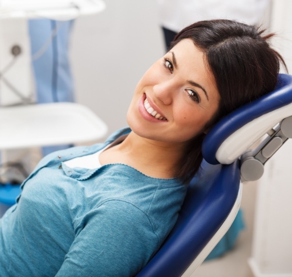 Smiling woman leaning back in dental chair in Raleigh dental office