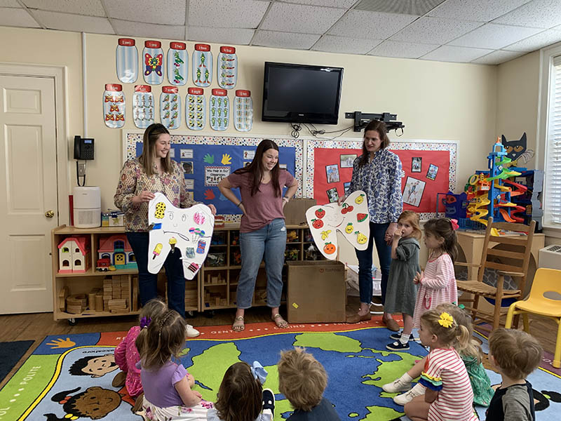 Raleigh dental team members giving presentation to classroom of children