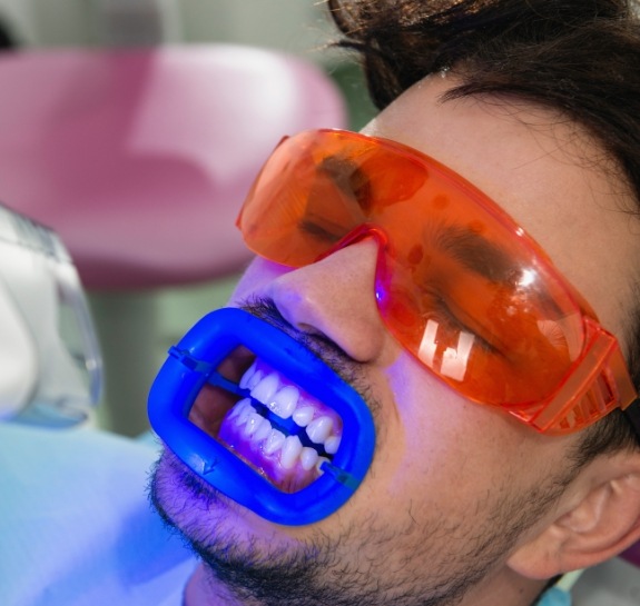 Man getting his teeth professionally whitened in dental office