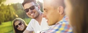 Group of adults in sunglasses smiling together outdoors