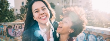 Two people laughing together outdoors