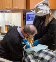 Doctor Helms and dental assistant treating a patient