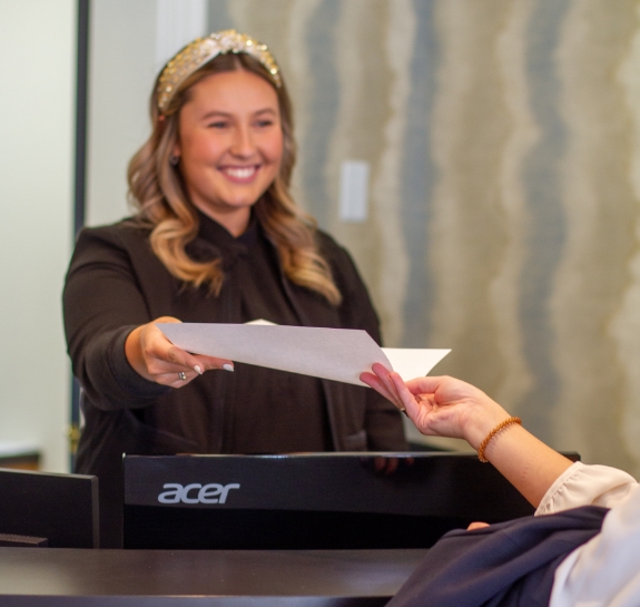 Raleigh dental team member handing a paper to a patient