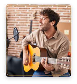 Man singing and playing acoustic guitar in front of red brick wall