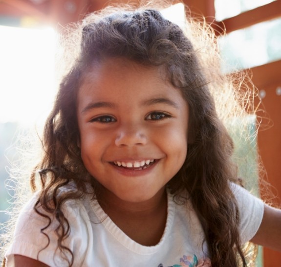 Young girl with long curly hair smiling