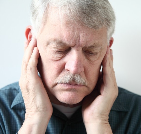 Man holding his temples in pain