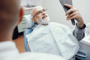 Older man smiling after cosmetic dental treatment